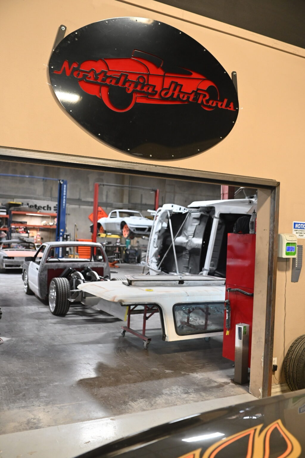 The Nostalgia Hot Rods shop floor in Henderson, with classic trucks mid-build under the shop sign