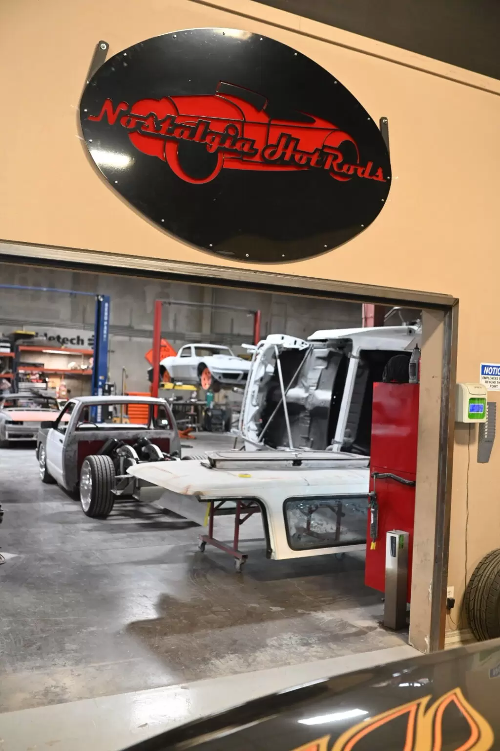 The Nostalgia Hot Rods shop floor in Henderson, with classic trucks partway through their builds under the shop sign